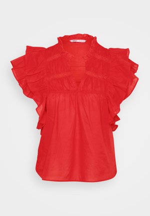 Punane pluus lühikeste volangkäistega, V-kujulise kaelusega ja kokku tõmmatud tekstuuriga. Valmistatud kergest kangast, millel on vabalt langev disain.