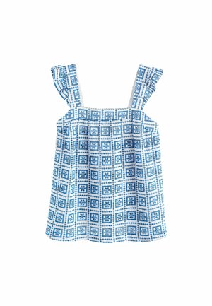 Witte mouwloze top met blauw vierkant en bloemmotief en gerimpelde schouderbandjes, plat gelegd op een witte achtergrond.