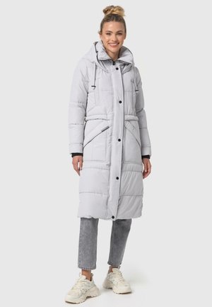 Long, light gray puffer coat with a hood, snap and zipper closures, side pockets, and quilted texture. Worn over gray jeans and white sneakers.