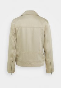 Chaqueta de lona beige con un diseño estructurado, que presenta un cuello con muesca, puños con cremallera y dos bolsillos traseros para almacenamiento.