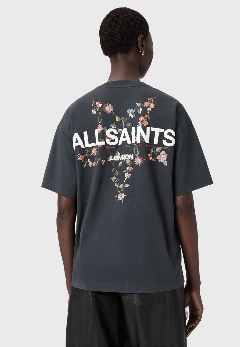 Hiilenharmaa puuvillainen t-paita, jossa kukkakuvio ja valkoinen "ALLSAINTS"-teksti selässä. Lyhyet hihat, rento istuvuus ja sileä pinta.