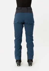Skibroek in teal met zwarte accenten, voorzien van een hoge taille, verstelbare riem, zijzakken en versterkte boorden voor duurzaamheid.