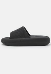 Black slide sandal with a textured upper and smooth sole, featuring a wide strap and a contoured footbed, made of lightweight synthetic material.