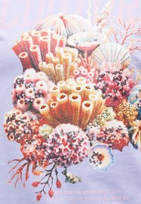 Χρωματιστό συστάδα κοραλλιογενών υφάλων με διάφορα σωληνοειδή και διακλαδωμένα κοράλλια, διακοσμημένα με λαμπερά παγιέτες σε ανοιχτό λιλά φόντο.