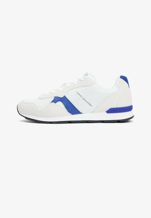 Weiß-blauer Sneaker mit niedrigem Schaft aus Mesh- und Wildlederdetails, schwarzer Sohle und "Tommy Hilfiger"-Logo an der Seite und Ferse.