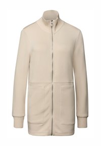 Veste beige zippée avec col côtelé, manches longues et deux poches avant. Texture lisse avec un design décontracté et une coupe ajustée.
