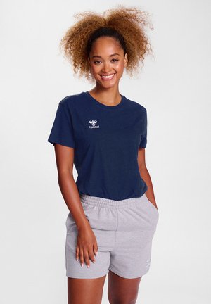 Navy short-sleeve t-shirt with a white logo, paired with light gray elastic waistband shorts featuring side pockets. Smooth, casual fabric.