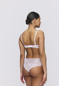 Biały koronkowy biustonosz i dopasowane majtki; miękkie elastyczne ramiączka, delikatne koronkowe wykończenie, przezroczysty materiał i zapięcie na hak z tyłu.