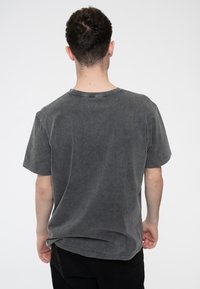 Gray cotton t-shirt with a relaxed fit, short sleeves, a round neckline, and a faded, slightly distressed texture.