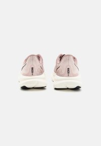 Rosa och vita löparskor med en texturerad ovandel, svarta accenter och en vadderad sula. Har "MACH 6" logotyp på hälen.