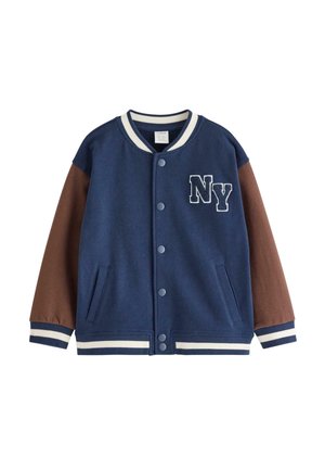 Blå og brun varsityjakke med trykknapper, hvidstribet krave og manchetter, sidelommer og "NY" patch på brystet.