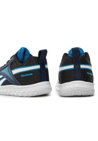 Pár čiernych a modrých športových topánok Reebok z pohľadu zozadu, s bielymi podrážkami a horizontálnym bielym a modrým pruhom.