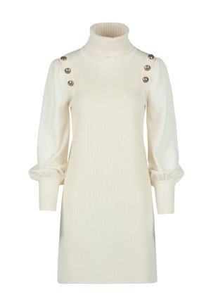 Kermakuvioinen turtleneck-mekko, jossa on ribbitekstuuri, puffihihat ja kolme kultanappikoristetta olkapäillä. Tiukka yläosa ja rento alaosa.