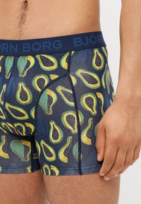 BJORNE BORG boxer alsónadrág sötétkék színben, színes, ismétlődő avokádó mintával; sima anyag, szoros illeszkedés és kontrasztos derékpánt.