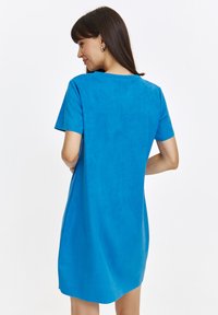 Sukienka z krótkim rękawem w intensywnym niebieskim kolorze, wykonana z miękkiego materiału o gładkiej fakturze. Posiada okrągły dekolt i luźny fason.
