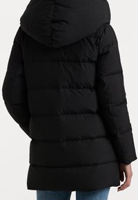 Černá péřová bunda s kapucí, která má prošívaný vzor a horizontální švy. Kratší délka s rovnými rukávy a bez viditelného kování.