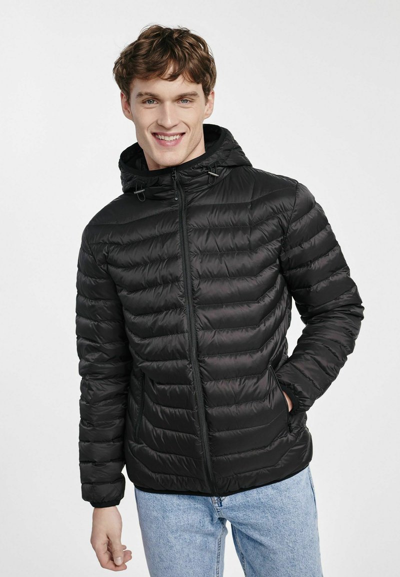 Czarna pikowana kurtka z zamkiem z przodu i kapturem, z poziomymi przeszyciami i bocznymi kieszeniami. Gładka faktura, luźny krój.