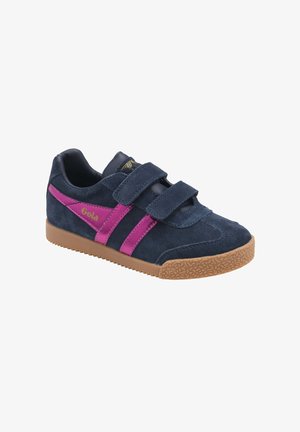Zapatilla deportiva de ante azul marino con rayas rosas, dos tiras de velcro, suela de goma marrón texturizada y la marca "Gola" en el lateral.