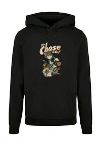Sort hættebluse med en frontlomme i kangaroo-stil, der viser et farverigt grafisk design af Tom og Jerry med teksten "Jagten er i gang!" i vintage stil.
