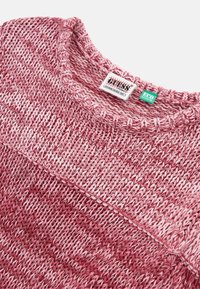 Sweter z dzianiny w gradientowych odcieniach różu, z okrągłym dekoltem, teksturowanym wzorem ściegów i metką pielęgnacyjną na kołnierzu.