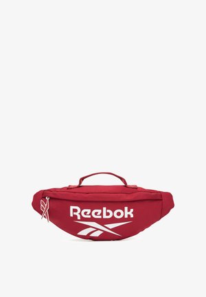 Riñonera roja de Reebok con logo blanco, asa superior y cierre de cremallera sobre un fondo blanco.