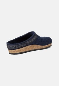 Zoccolo in felt blu navy con suola in sughero. Presenta una fascia testurizzata con un motivo lungo la parte superiore. Design con schienale basso per una facile calzata.