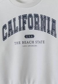 Felpa bianca con testo blu scuro che riporta "CALIFORNIA," "USA," e "THE BEACH STATE - LOS ANGELES," con colletto e polsini a coste.