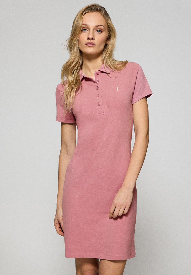 Różowa sukienka polo wykonana z bawełny, z krótkimi rękawami, kołnierzykiem oraz zapięciem na guziki. Małe logo na piersi. Gładka, jednolita faktura.