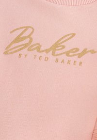 Felpa rosa realizzata in tessuto a costine, con un logo dorato in corsivo che recita "Baker by Ted Baker". Collo rotondo.