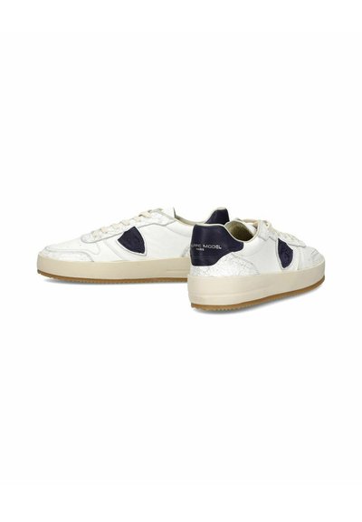 Baskets en cuir blanc avec des accents bleu marine, un design texturé, un bout rond et une semelle en caoutchouc gomme. Fermeture à lacets pour un maintien sécurisé.
