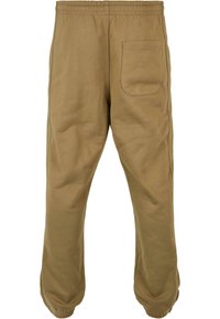 Kokvilnas twill joggeri khaki krāsā ar elastīgu jostasvietu, ar apdari potītēs un vienu aizmugurējo kabatu. Gluda tekstūra ar ikdienišķu dizainu.