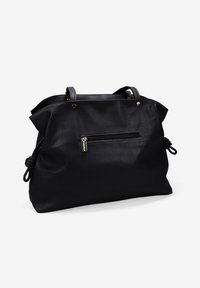 Bolso de mano de cuero negro con una superficie texturizada, doble asa en la parte superior, un bolsillo frontal con cremallera y detalles atados en los laterales.