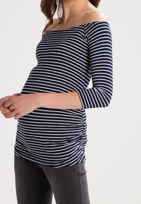 Marineblau-weiß gestreiftes, schulterfreies Maternity-Oberteil mit drei Viertelärmeln, das aus strukturiertem Stoff gefertigt ist und über geraffte Seitendetails verfügt.
