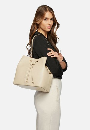 Borsa a secchiello in pelle beige con chiusura a coulisse, forma strutturata e due spallacci. Superficie testurizzata con minimi accenti in metallo.