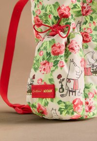 Moomin mintás hátizsák virágmintával zöld, rózsaszín és piros színben. Piros pánttal és márkázott taggel rendelkezik, játékos illusztrációkkal.