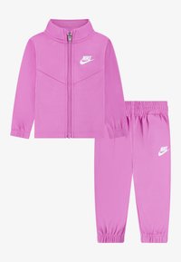 Rosa Nike-Trainingsanzug mit einer Reißverschlussjacke mit Kragen und elastischen Bundhosen. Beide Teile sind mit einem weißen Nike-Logo versehen.