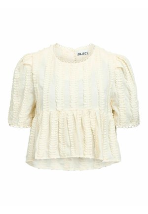 Blouse courte texturée à manches courtes avec manches bouffantes, ourlet peplum et délicate bordure festonnée le long de l'encolure et des poignets.