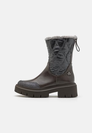 Bruine leren enkelboots met een zwarte gewatteerde bovenkant, grijze nep bontvoering en een gestructureerde platformzool; heeft een bloemenaccent aan de zijkant.