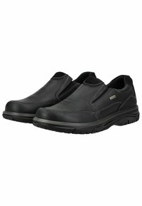 Schwarze Slipper aus glattem Leder mit kontrastierenden weißen Nähten, elastischen Seiteneinsätzen und einer strukturierten Gummisohle.