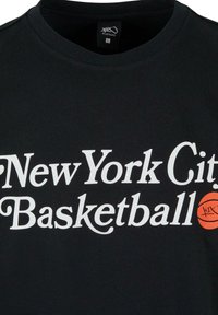 Sort bomulds T-shirt med fed hvid tekst "New York City Basketball" og et orange basketball-grafik på højre side.