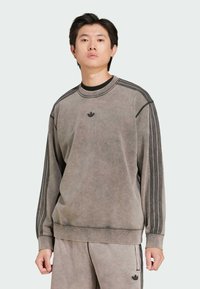 Grå texturerad sweatshirt med rund hals, långa ärmar och tre svarta ränder på varje axel, samt en liten logotyp på bröstet.