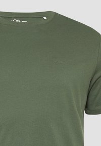 Olijfgroen katoenen T-shirt met een ronde hals en korte mouwen. Heeft een subtiel s.Oliver-logo geborduurd op de borst. Glad materiaal.