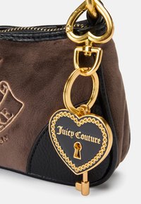 Brun ruskind og sort læder taske med et guld hjerteformet vedhæng med "Juicy Couture", nøgleaccent og en tekstureret finish.