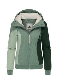 Veste à capuche verte avec un intérieur doux en fourrure. Elle dispose d'une fermeture éclair, de poignets élastiques et d'un design en blocs de couleurs dans différentes nuances de vert.
