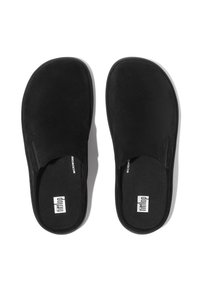Zapatos negros tipo slip-on con parte superior de suave ante, plantilla acolchada y diseño minimalista. Presenta etiquetas de marca en el interior.