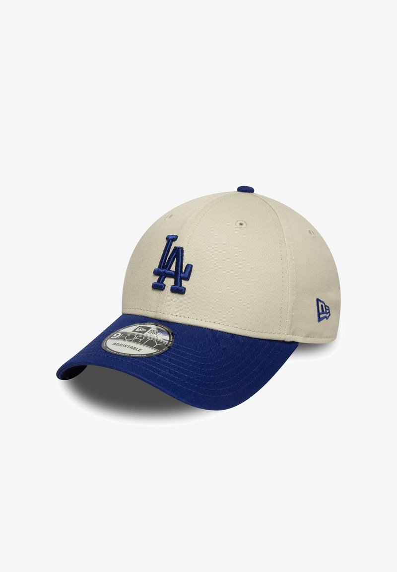 Casquette beige avec une visière bleue, ornée d'un logo LA bleu brodé à l'avant. Le design comprend une sangle ajustable et un tissu texturé.