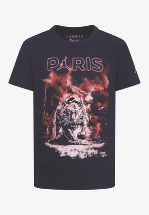 Sort T-shirt med teksten "PARIS", Jordan-logo som bogstav A og grafik af en brølende tiger mod en rød lynbaggrund.
