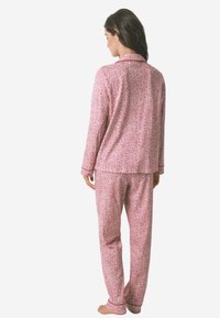Rosa Blumen-Pyjama-Set mit einem langen, kragenlosen Oberteil und passenden Hosen, aus weichem Stoff mit gemusterter Textur gefertigt.