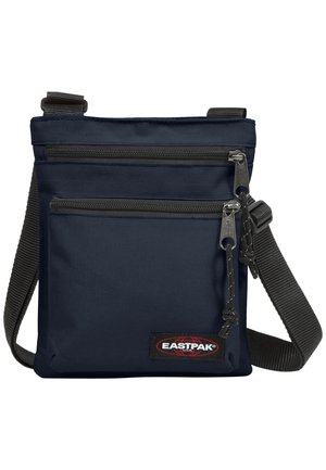 Granatowa torba na ramię z dwoma kieszeniami na suwak, regulowanym czarnym paskiem i naszywką z logo Eastpak na przedniej kieszeni.