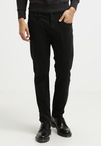 Svarta slim-fit byxor i bomull, med framfickor, en mjuk textur och ihop med svarta läderskor.